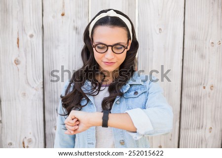 Pretty hipster checking the time against bleached wooden fence