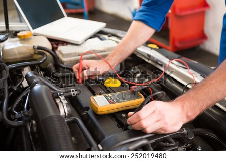 Mechanic using diagnostic tool on engine at the repair garage