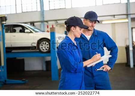 Team of mechanics talking together at the repair garage