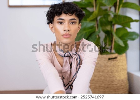 Stylish transgender woman sitting in armchair on terrace