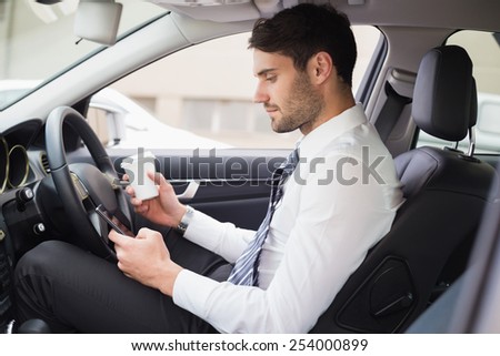 Young businessman having a coffee in his car