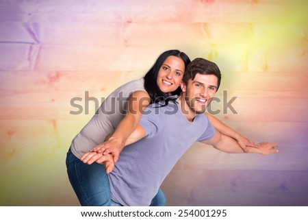 Man giving his pretty girlfriend a piggy back against yellow and purple planks