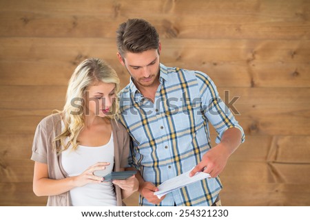Attractive couple working out their finances against bleached wooden planks background