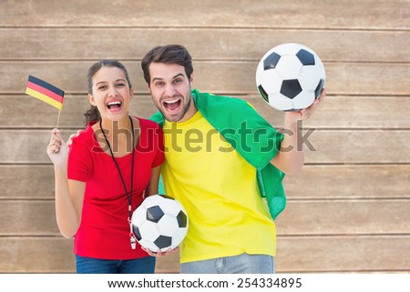 Football fan couple cheering and smiling at camera against wooden surface with planks
