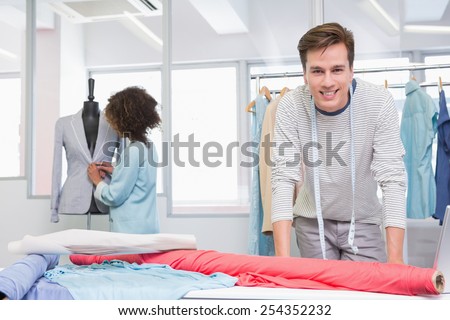 Smiling students working with fabric and model at the college