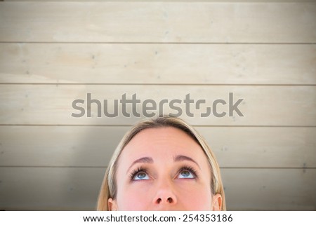 Close up of blonde woman looking up against bleached wooden planks background