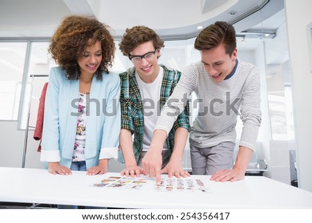 Students working together with photos at the college