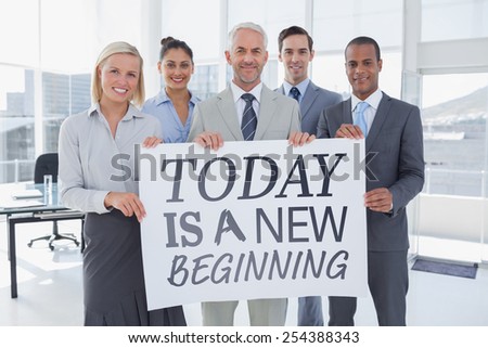 Business team holding large blank poster against today is a new beginning