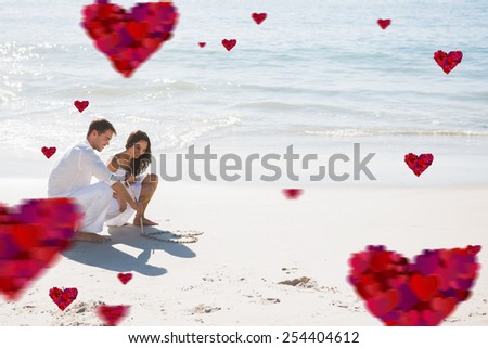 Cute couple drawing a heart in the sand against hearts