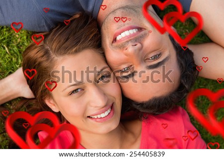 Close up of two friends looking upwards while lying head to shoulder against hearts