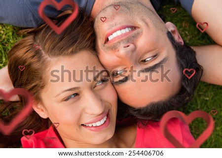 Close up two friends looking at each other while lying head to shoulder against hearts