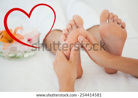 Woman receiving a foot massage against heart