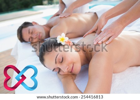 Attractive couple enjoying couples massage poolside against linking hearts