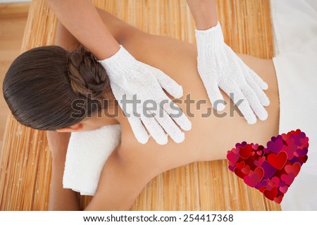 Beautiful brunette enjoying a back massage against heart