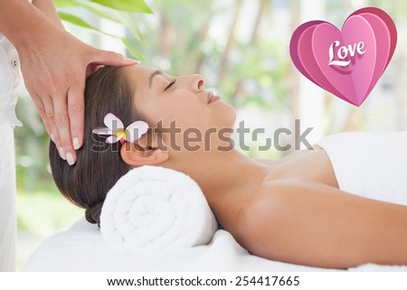 Beautiful brunette enjoying a head massage against love heart