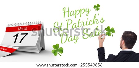 Rear view of businessman writing with marker against shamrock