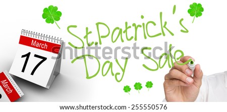 Businessman writing on camera with a black marker pen against shamrock