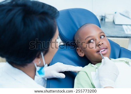 Close up of dentist examining a boys teeth in the dentists chair