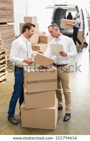 Warehouse managers checking their list in a large warehouse