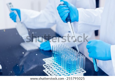 Science students using pipettes to fill test tubes at the university