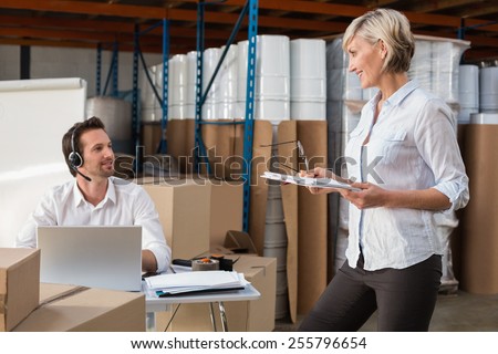 Smiling warehouse managers talking together in a large warehouse