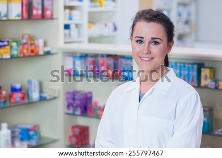 Portrait of a smiling student in lab coat looking at camera in the pharmacy