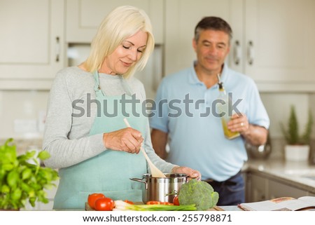 Mature couple making dinner together at home in the kitchen