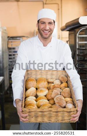 Baker holding basket of bread in the kitchen of the bakery