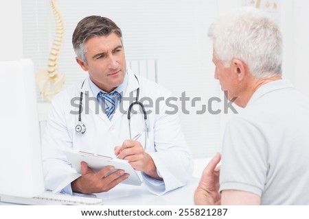 Senior male patient sharing problems with doctor in clinic