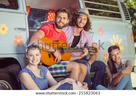 Hipster friends by their camper van on a summers day