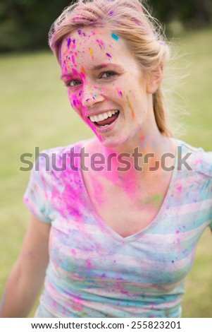 Young woman having fun with powder paint on a sunny day