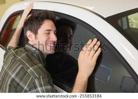 Man hugging on a car at new car showroom