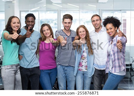 Portrait of happy college students gesturing thumbs up
