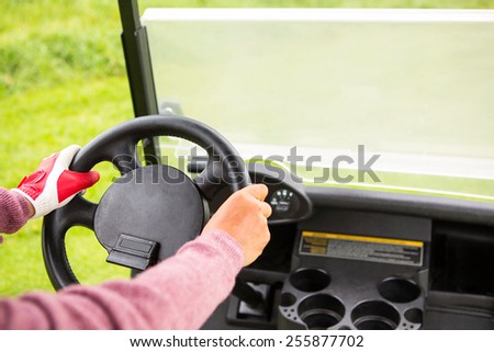 Golfer driving his golf buggy forward at the golf course