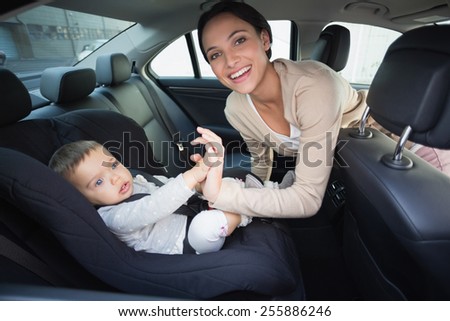 Mother securing her baby in the car seat in the car