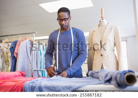 University student cutting fabric with a pair of scissors at the university