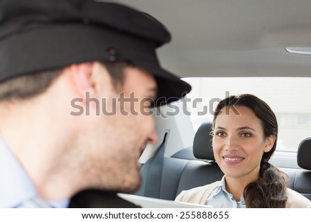 Young businesswoman being chauffeured while working in the car