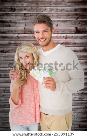 Attractive couple flashing their cash against wooden planks