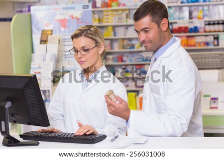 Team of pharmacists looking at the computer at the hospital pharmacy