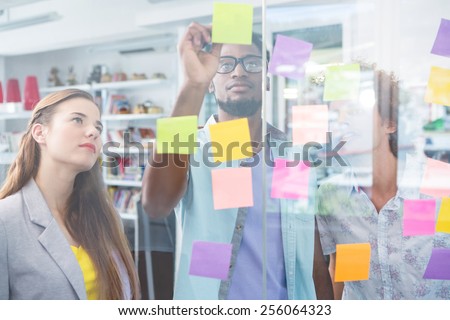 Creative business team writing on adhesive notes in office