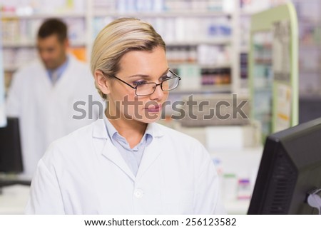 Concentrate pharmacist looking at computer at the hospital pharmacy