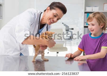 Veterinarian examining a cat with its owner in medical office