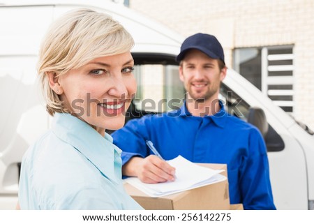 Happy delivery man with customer outside the warehouse