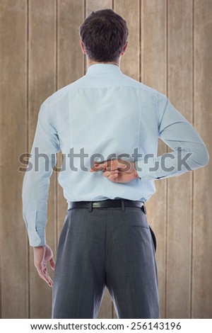 Businessman crossing fingers behind his back against wooden surface with planks