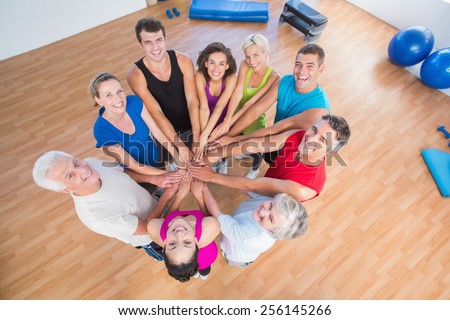 High angle portrait of fit people stacking hands at health club