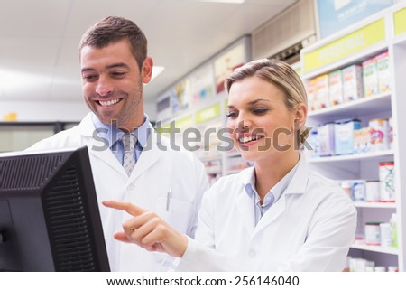 Team of pharmacists looking at computer at the hospital pharmacy