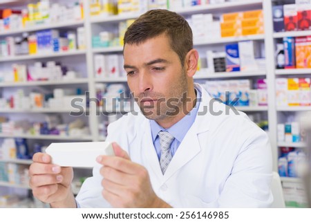 Handsome pharmacist holding paper at the hospital pharmacy