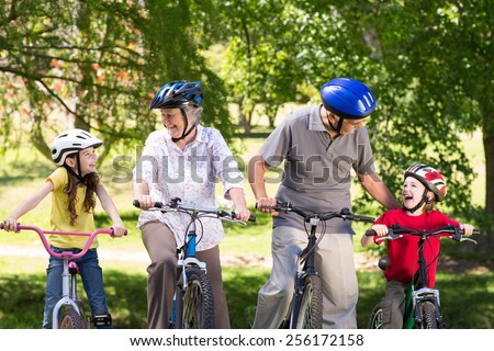 Happy grandparents with their grandchildren on their bike on a sunny day