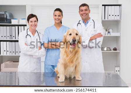 Veterinarian coworker smiling at camera with dog in medical office