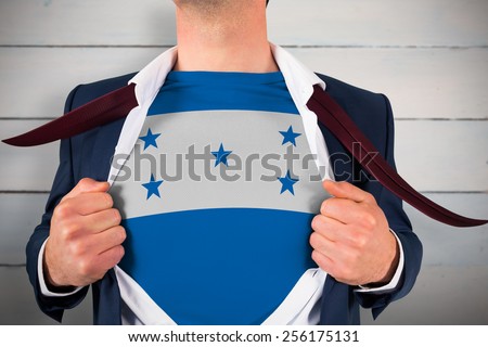 Businessman opening shirt to reveal honduras flag against painted blue wooden planks